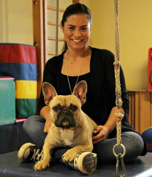 Hundetrainerin mit Hund auf dem Schoss