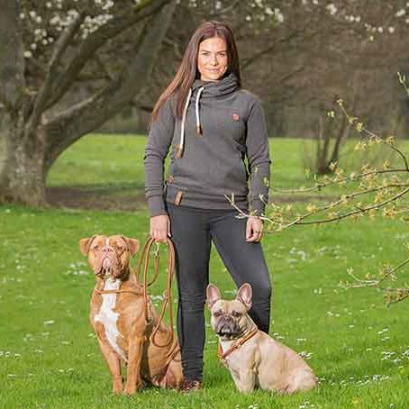 Hundetrainerin mit zwei Hunden an der Leine