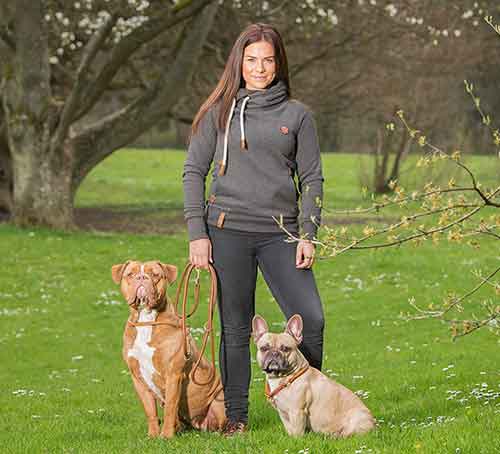 Hundetrainerin mit zwei Hunden an der Leine